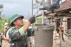 第五军区军事学校士兵为得乐省和美乡村民建房。图自越通社