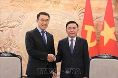 越共中央政治局、中央书记处常务书记陈锦秀（右）与老挝革命党中央对外部代理部长本莱·班达努冯。图自越通社