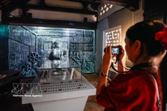 参观者参观“青史留名”展览，该展览采用传统展示形式结合数字化技术。图自越通社