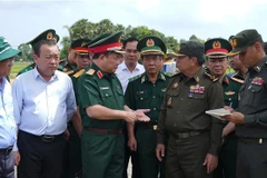越南国防部副部长黄春战中将（左三）与柬埔寨皇家陆军副总司令伊萨拉将军（右二）讨论在柬埔寨柴桢省柴桢县建设桑索瓦纳小学友谊项目计划。图自越通社