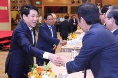 越南国家主席梁强和政府总理范明政与各位代表亲切握手。图自越通社