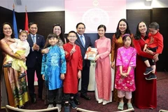 越南政府总理范明政和夫人向旅居爱沙尼亚的越南人赠送越南语书籍。图自越通社