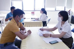 北江省就业服务中心工作人员协助企业招聘员工。图自越通社