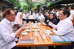 范明政与马来西亚总理安瓦尔·易卜拉欣参观图书街 品尝越南咖啡