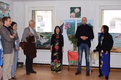 旅居比利时越南女画家金团和代表们在“爱之土地”的画展开幕式上。图自越通社