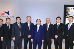 政府总理阮春福与新加坡一流企业集团领导代表合影。（图片来源：越通社）