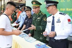 越中边防配合向在国际友谊口岸（越南）和友谊关（中国）出入境的人们发放宣传单。图自越通社 