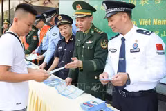 越中边防配合向在国际友谊口岸（越南）和友谊关（中国）出入境的人们发放宣传单。图自越通社 