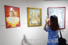 美术爱好者参观展会上展示的作品。（图片来源：越通社） 