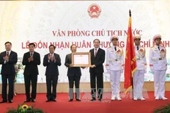 陈大光将胡志明勋章佩戴在国家主席办公厅传统旗之上。