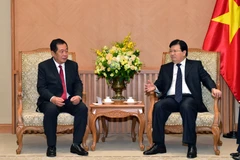 越南政府副总理郑廷勇（右）会见老挝邮电部部长他夏米·蓬玛占。（图片来源：越通社）