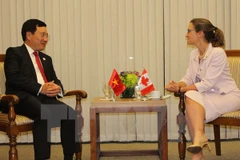 越南政府副总理兼外长范平明(左）会见加拿大外交部长克里斯蒂娅·弗里兰。（图片来源：越通社）
