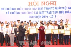 越南国会主席阮氏金银向全国乡级祖国阵线委员会主席和阵线工作委员会优秀主任授予政府总理奖状。（图片来源：越通社）