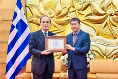 VUFO主席潘英山向希腊驻越大使乔治•伊利奥普洛斯授予“致力于各民族和平与友谊”奖章。图自越通社