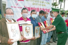 朔庄省边防部队向渔民赠送国旗和胡志明主席肖像