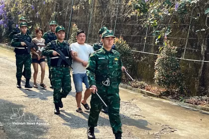 老街国际口岸边防部队押解“LC326”专案2名涉嫌贩运人口犯罪嫌疑人。图片来源：越通社