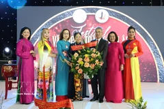 越南驻德国大使阮得成向欧洲越南女企业家协会主席郑氏未赠送鲜花表示祝贺。图自越通社