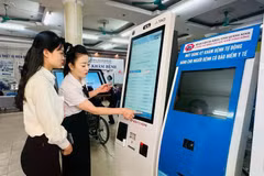 广宁省综合医院医务人员指导民众使用自助挂号机。图自Vietnam+