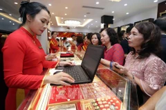 人们在孟海保信金店排队买黄金。图自越通社