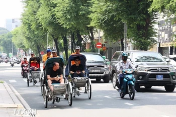游客乘坐人力三轮车参观胡志明市中心。图自越通社