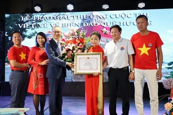 武光明大使向获奖者颁发奖状。图自越通社
