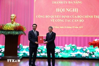 黎明兴同志向黎玉光同志颁发越共中央政治局的任命决定。图自越通社