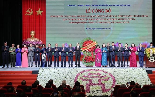 国家主席梁强敬献花篮,向河内市委、市政府和人民表示祝贺。图自越通社 vna-potal-chu-tich-nuoc-du-le-cong-bo-nghi-quyet-quyet-dinh-sap-nhap-don-vi-hanh-chinh-tai-ha-noi-8122029.jpg