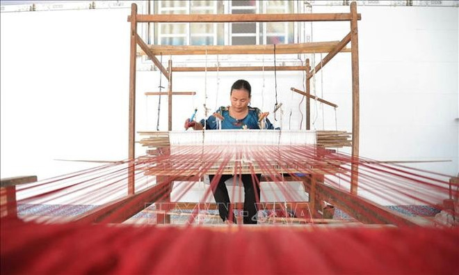 文教织锦合作社主任内昂·橙多司(Neáng Chanh Da Ty)用手工织布机织布。图自越通社 tho-cam-16022025.jpg