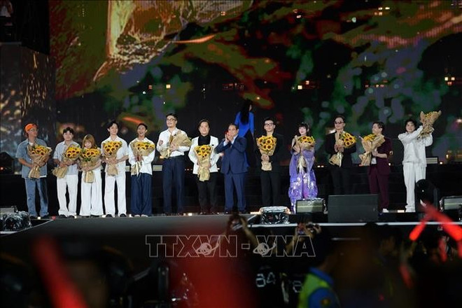 越南政府总理范明政向“V Fest-今日越南”大型文艺晚会的组委会和艺术家代表赠送鲜花。图自越通社 thu-tuong-3.jpg