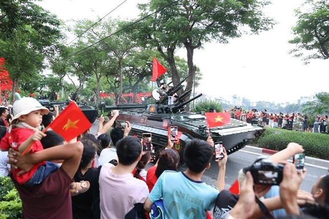 尽管天气时而酷热、时而大雨,民众仍耐心等待。图自越通社 vna-potal-cac-luc-luong-san-sang-cho-tong-hop-luyen-dieu-binh-dieu-hanh-a80-lan-thu-2-8231418.jpg