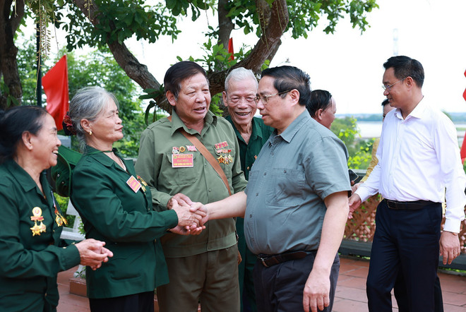 范明政与来到龙大二号渡轮码头历史遗址为英烈进香的前青年志愿者和火线民工亲切握手。图自越通社 vna-potal-thu-tuong-dang-huong-tuong-niem-anh-hung-liet-si-tai-quang-tri-8174387.jpg