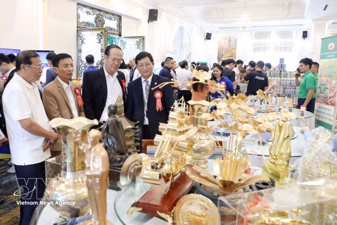 参加贸易促进会议的代表们参观会议期间举行的展销会。图自越通社