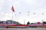 人民空军直升机编队悬挂党旗与国旗飞越河内上空。图自越通社