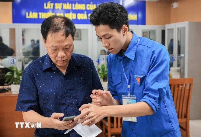 团员指导群众在智能手机上使用和申报各项网上公共服务。图自越通社 chuyen-doi-so-chinh-quyen-2-cap-2.jpg