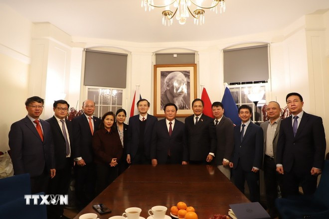 政治局委员阮春胜与越南驻英国大使馆干部、工作人员合影留念。图自越通社 nguyen-xuan-thang-tham-lam-viec-tai-vuong-quoc-anh-8281399.jpg