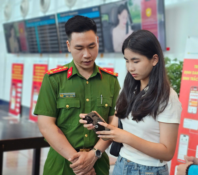 公安人员指导乘客在 VNeID 应用程序上办理在线值机手续。图自越通社 vna-potal-ung-dung-nhan-dien-sinh-trac-hoc-tai-cang-hang-khong-quoc-te-tan-son-nhat-8173003.jpg