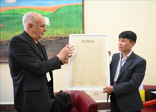 古巴记者联合会主席里卡多·龙基略·贝洛向越南记者协会常务副主席阮德利赠送“Patria”首刊副本。图自越通社 cuba1-20325.jpg