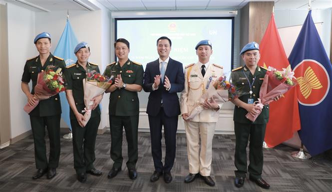 越南常驻联合国代表团团长邓黄江大使向联合国维和局的干部送花。图自越通社
