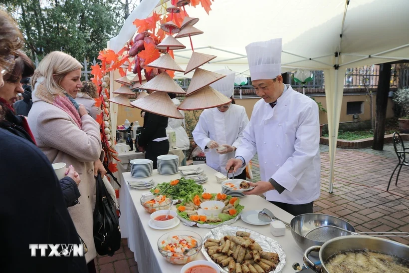 越南驻意大利大使杨海兴向食客介绍越南河粉和春卷。图自越通社