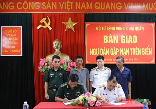 海军第三区司令部和山茶边防屯的代表签署并交接了两名遇险渔民。图自人民军队报