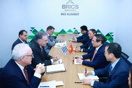 越南政府总理范明政在2025年7月7日举行的金砖国家（BRICS）扩展峰会期间会见乌拉圭总统亚曼杜·奥尔西。图自越通社