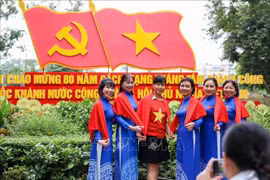 临近国庆，许多河内市民走上街头，与祖国红旗合影，以表达爱国之情和民族自豪感。图自越通社