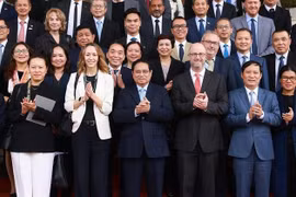 范明政总理与与会代表合影。图自越通社