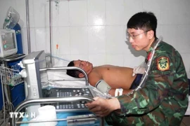 军医为患者进行腹部超声检查。图自越通社