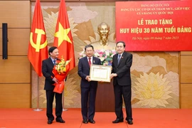 武海河同志荣获党龄30年党徽。图自越通社