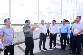 越南政府总理范明政考察社会住房发展情况并视察横跨香江的阮黄大桥。图自越通社
