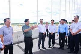 越南政府总理范明政考察社会住房发展情况并视察横跨香江的阮黄大桥。图自越通社