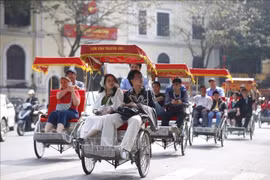 游客乘坐人力三轮车环游还剑湖，体验观光之旅。图自越通社