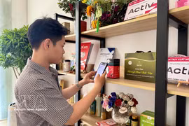 消费者扫描产品二维码，了解产地来源信息。图自越通社