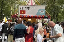游客排队品尝“We love Phở”展位的牛肉粉。图自越通社